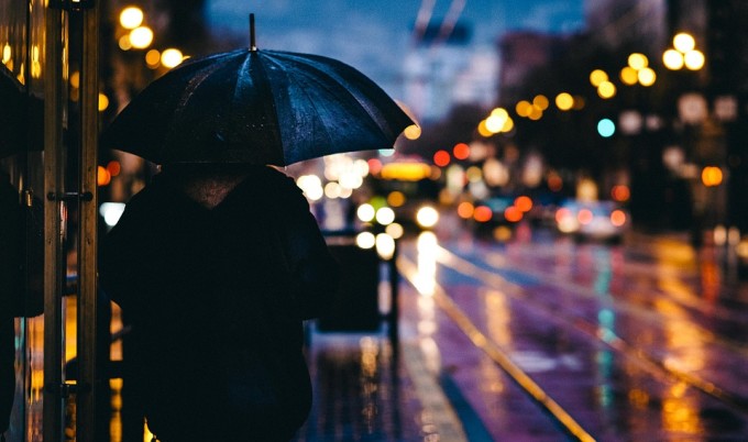 A person with his umbrella under the rain.